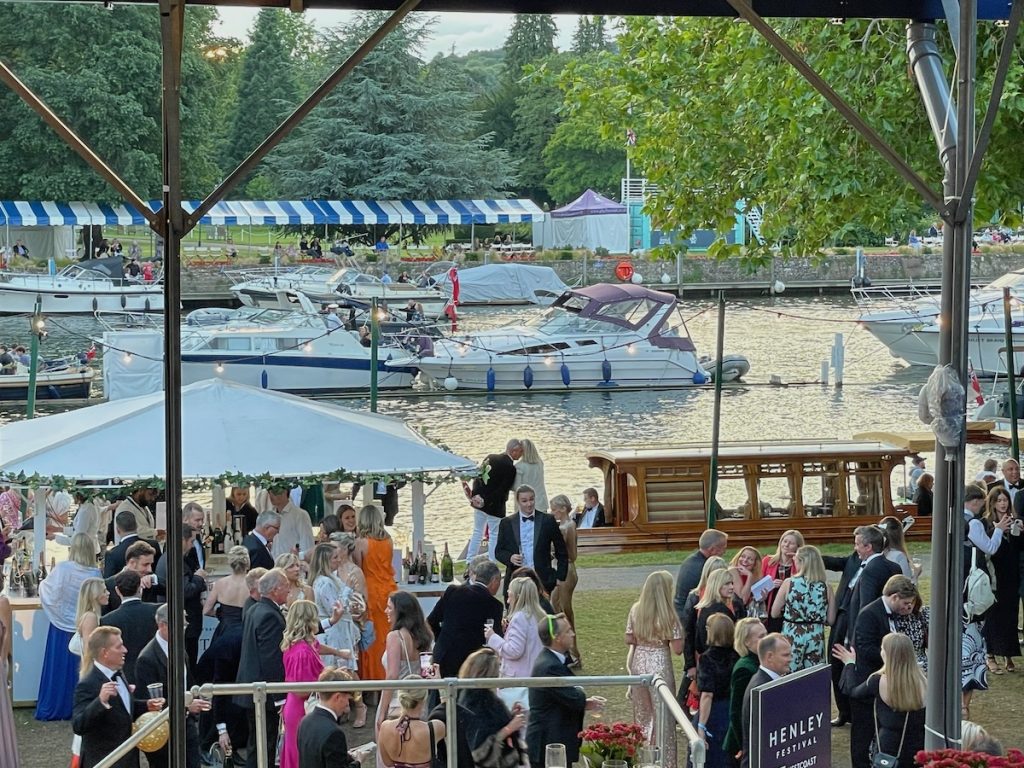 Henley festival champagne trader in front of the river thames with people buying champagne of the trader WiFi network