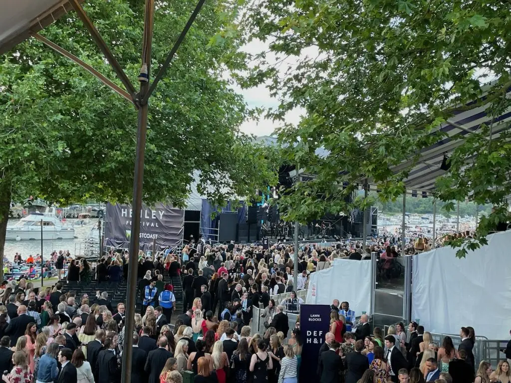 Henley Festival floating stage with black tie guests watching the gospel choir warm-up act.